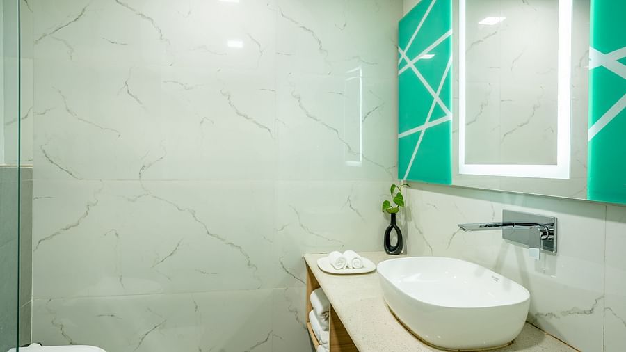 An image of a bathroom with a faucet and a sink | Inde Hotel Golf Course Extension