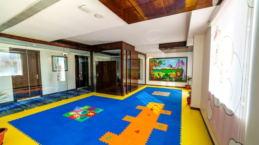 Children's playroom at Inde Reva Resorts Rishhikesh with colourful flooring, soft blocks, indoor lighting, and wall mural.