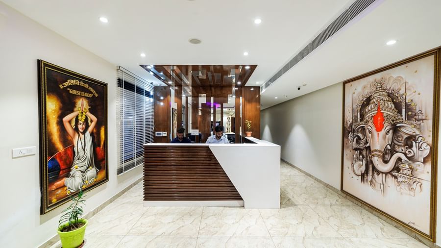 Reception area at Inde Reva Resorts Rishhikesh with front desk, ceiling lights, and wall art on both sides.