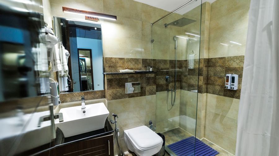 Modern furnished bathroom at Inde Reva Resorts Rishhikesh featuring a toilet, and a vanity unit.