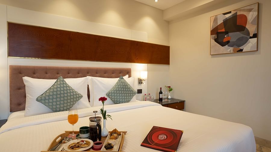 Club Room with a large double bed with decorative amenities artistically arranged at Inde Signature Jaipur.