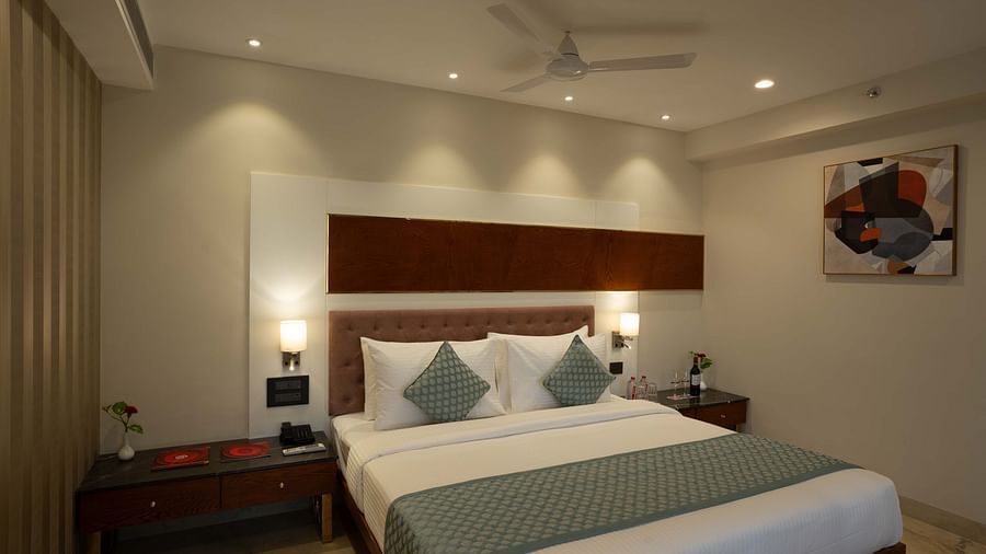 Club Room with a large double bed with decorative amenities artistically arranged at Inde Signature Jaipur.