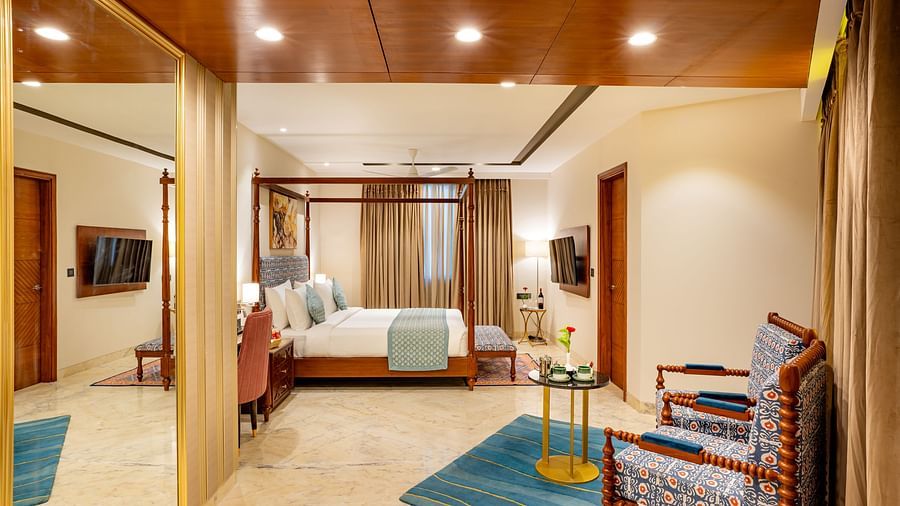 Spacious Suite with double bed, wooden bed side table, comfortable seating,wall mounted television, big window with curtains at Inde Signature Jaipur