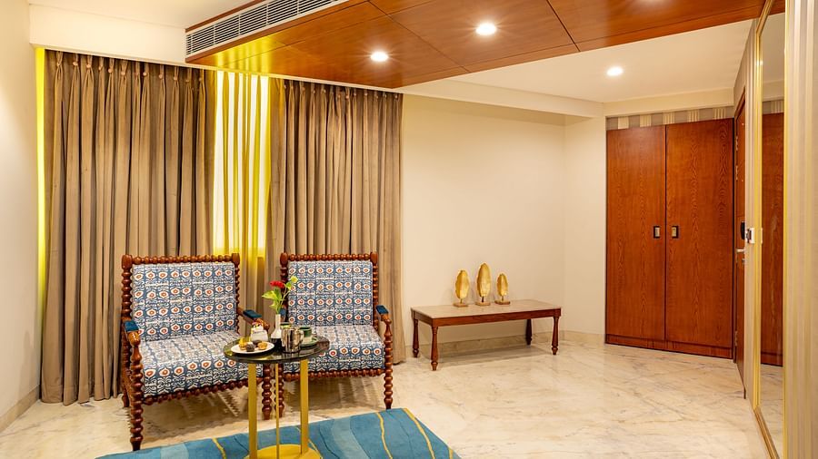 Two cushion seatingTwo cushioned seats with a wooden decorative round table and a rectangular side table in the Suite at Inde Signature Jaipur with a wooden decorative round table and side rectangle table in Suite at Inde SIgnature Jaipur