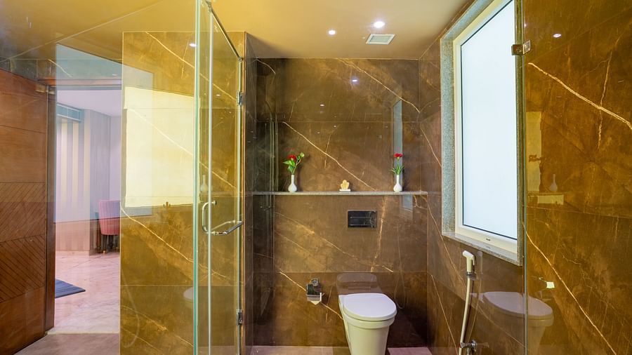 Large washroom with glass dividers that separate the showering and toilet areas