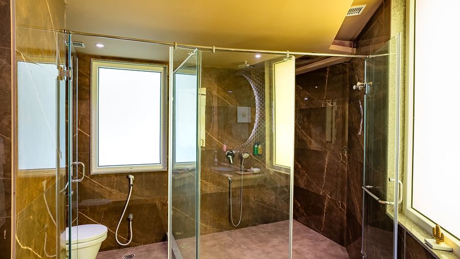 Large washroom with glass dividers that separate the showering and toilet areas