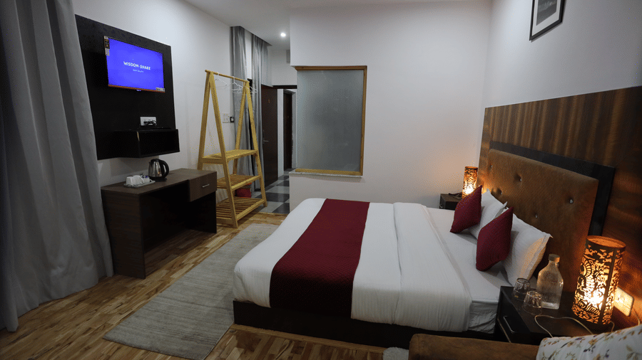 A room with a large bed, pillows, spreads, television, and wall arts. | Indus Serinity, Leh Ladakh