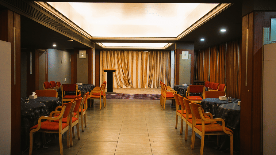 Infiniti Hotel, Indore | A banquet hall with chairs and tables.
