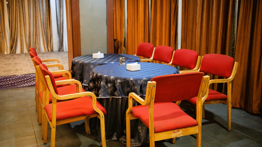 Infiniti Hotel, Indore | A banquet hall with chairs and tables set for an event.
