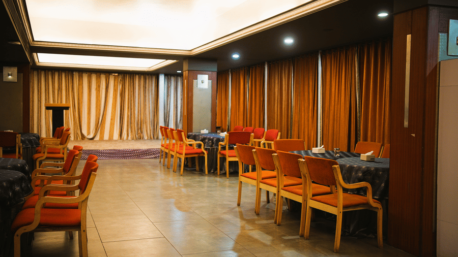 Infiniti Hotel, Indore | A banquet hall with chairs and tables.