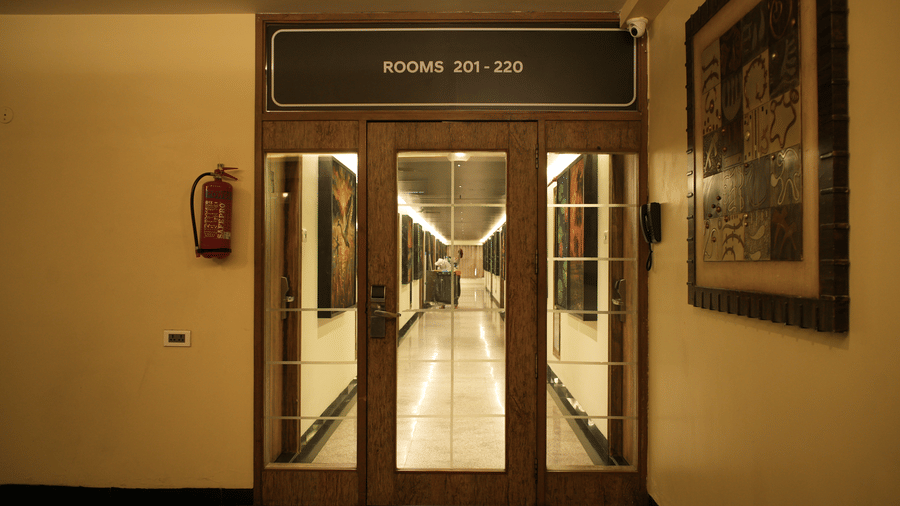 A wooden glass door leading to guest rooms at Infiniti Hotel, Indore.