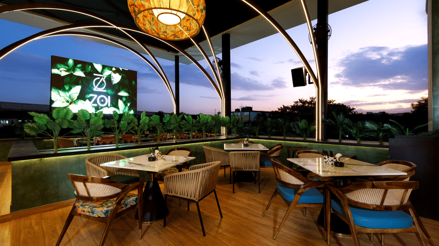 An image of a well lit restro bar with several chairs and table