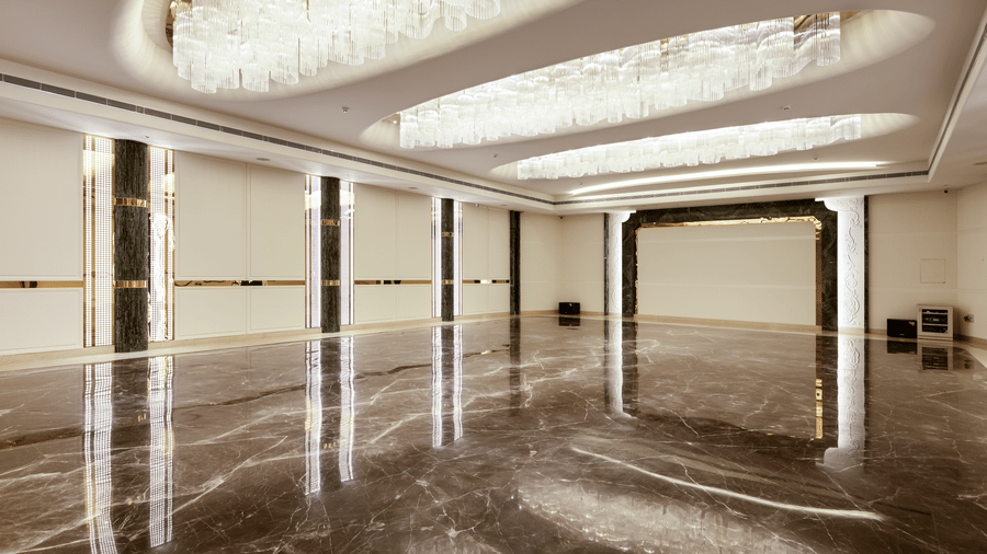Emerald Hall at Jenneys Residency showcasing an elegant archway, crystal chandeliers, and polished marble flooring, perfect for grand celebrations.