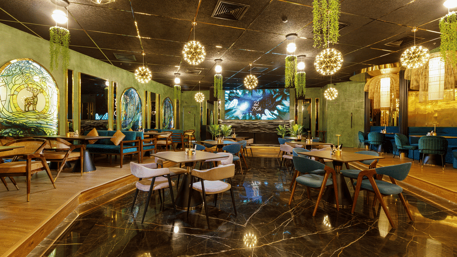 A contemporary bistro space with unique spherical pendant lights and green decorative elements - Jenneys Residency, Coimbatore