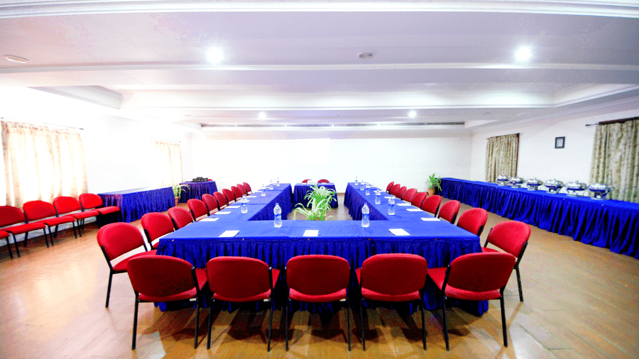 A professional conference room arranged in a U-shape seating layout with a head table - Jenneys Residency, Coimbatore