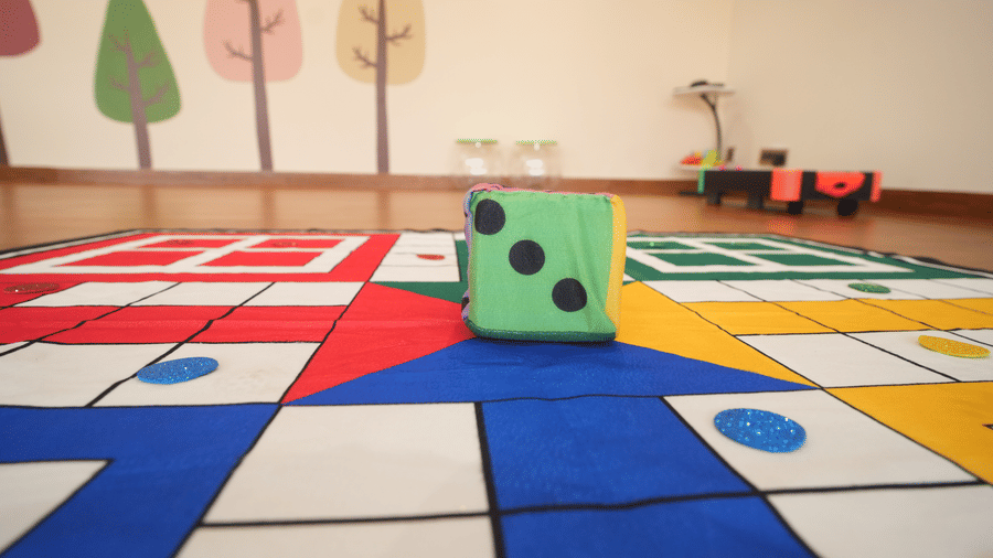 Kids play area at Kadamb Kuteer with a big ludo mat and dice.