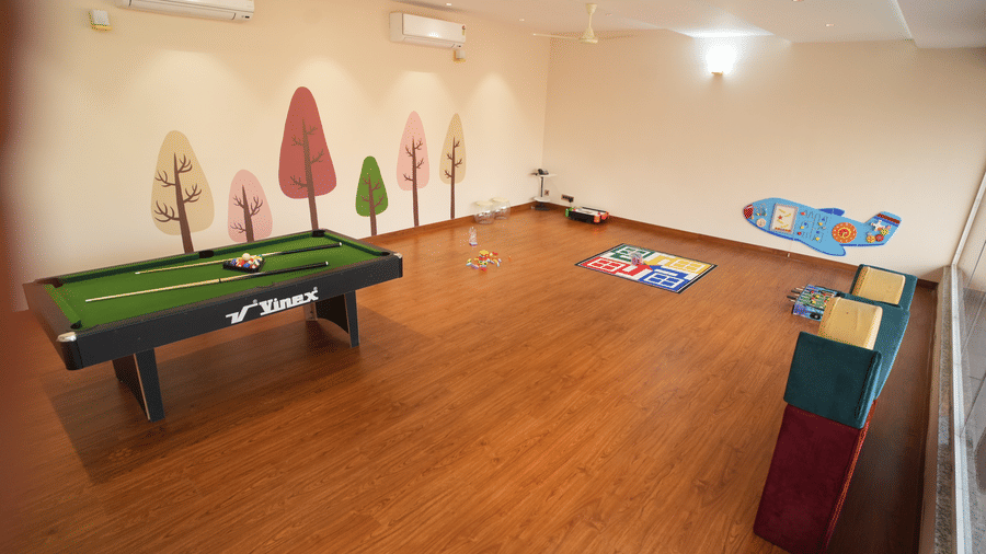 A spacious kids play area featuring a a pool table, a puzzel set, and large ludo mat  at Kadamb Kuteer, Vrindavan
