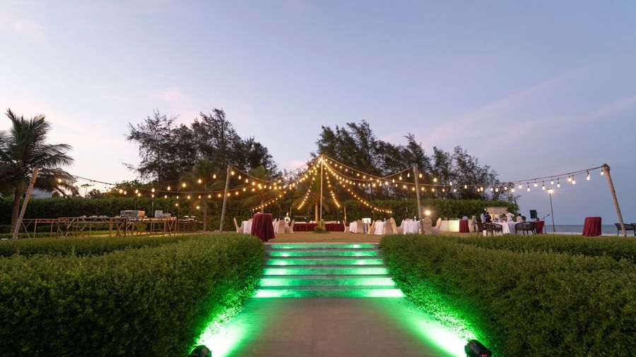 Garden pathway illuminated with green lights leading to an event area - Kaldan Samudra Palace