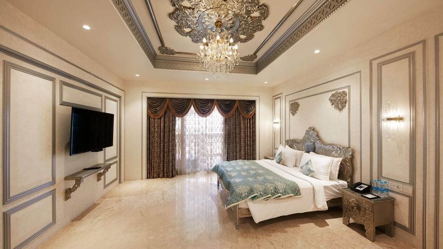 A spacious bedroom in our villa in Mahabalipuram featuring a king-size bed with pastel pillows and an ornate ceiling design – Kaldan Samudra, one of the finest luxury resorts in Mahabalipuram