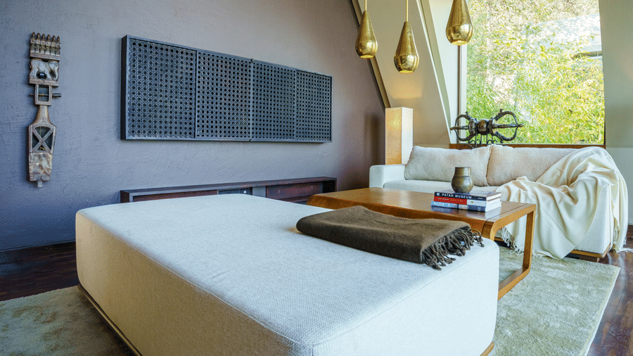 Elegant luxury room at Kavya Himalayas featuring a minimalist bed setup warm interiors modern lighting and large windows overlooking lush natural surroundings