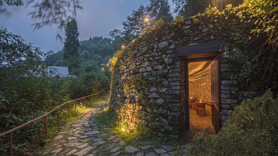 A small cottage with lights on and a pavement wit grasses on each side | Kavya Resort and Spa, Nagarkot
