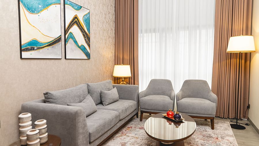 sitting area of the one bedroom suite of Kertel Suites, kinshasa with two wall mounted paintings above the sofa set