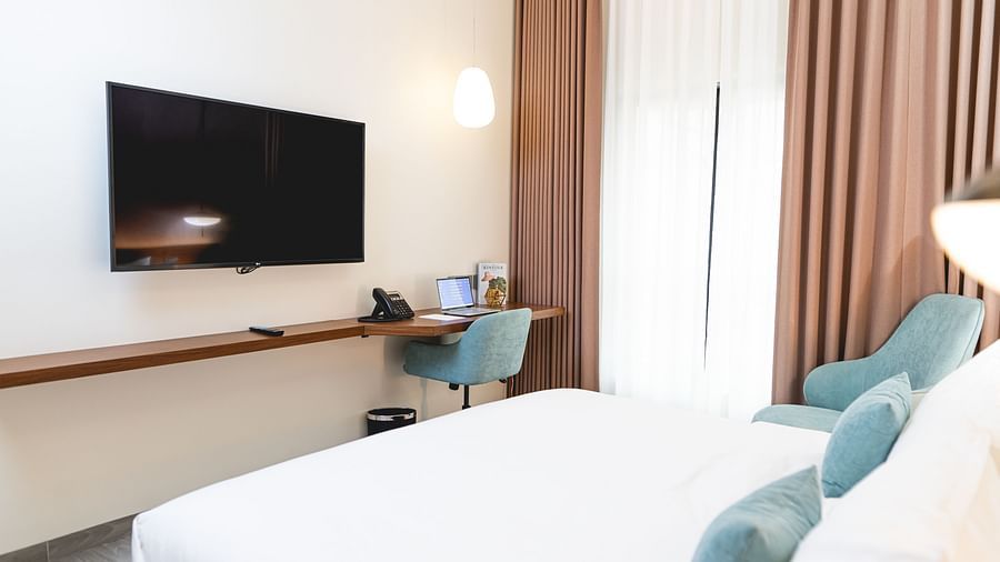 image of the standard room at Kertel Suites, kinshasa featuring a wall mounted television placed opposite to a double bed
