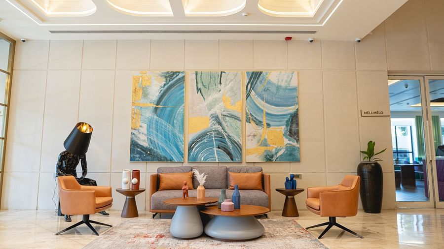 Lobby at KertelSuites, featuring a cosy sofa, a round coffee table, and an elegant ceiling with stylish lighting.
