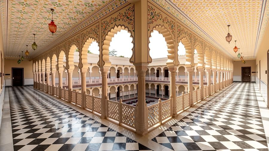 Ornate palace corridor with arches and black-and-white flooring