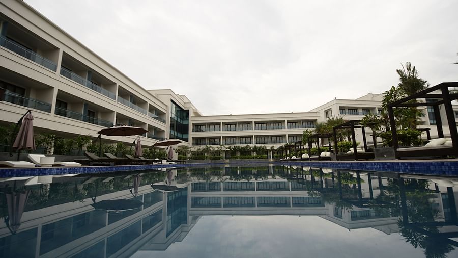 A facade view of the hotel, with the reflection of the building in the swimming pool