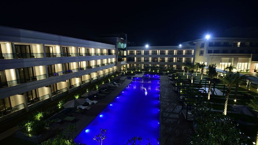  A facade view of the hotel, with the swimming pool glowing under the night lights