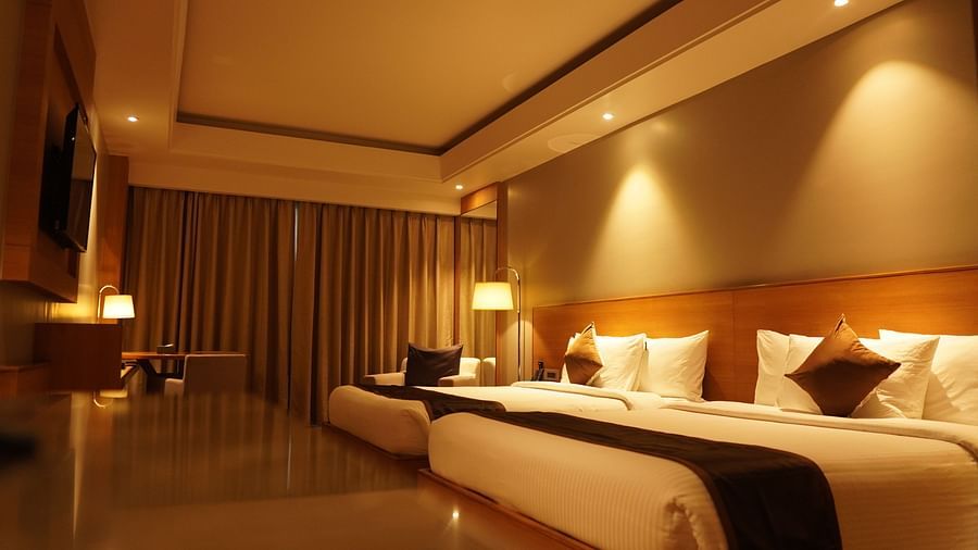 Two spacious beds with warm lighting and neatly made sheets