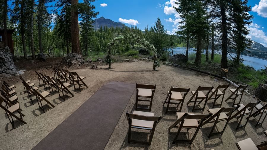 Outdoor ceremony setup with wooden chairs and forest views at Kit Carson Lodge.