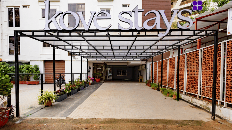 The covered entryway with a 'Kove stays' sign leading toward the ground-floor entrance of the multi-storey building of Kove Smart Stays.