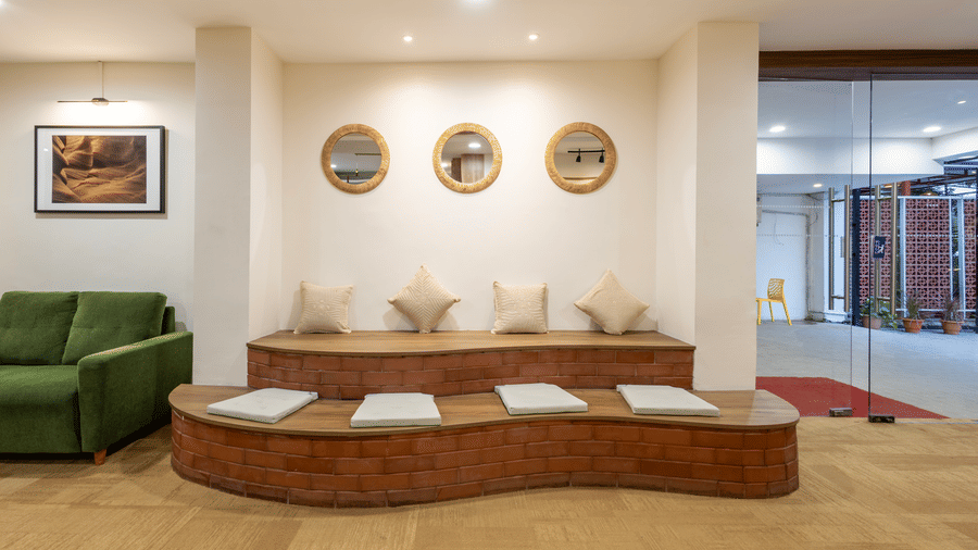 Close up of a specific upholstered seating area with 2 layers of seating furnished with cushions, seen in the lobby of Kove Smart Stays.