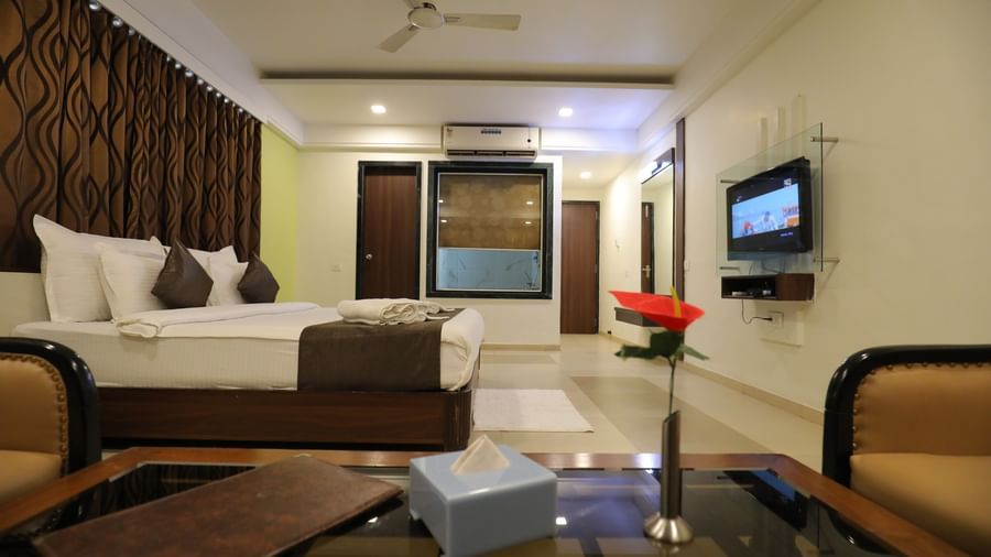 A bedroom at Krushnai Resort featuring a large bed, a TV, and modern interiors.