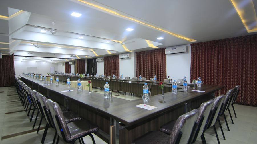 A meeting room at Krushnai Resort with a central long table surrounded by chairs in a conference arrangement, and complemented by multiple air-conditioners.