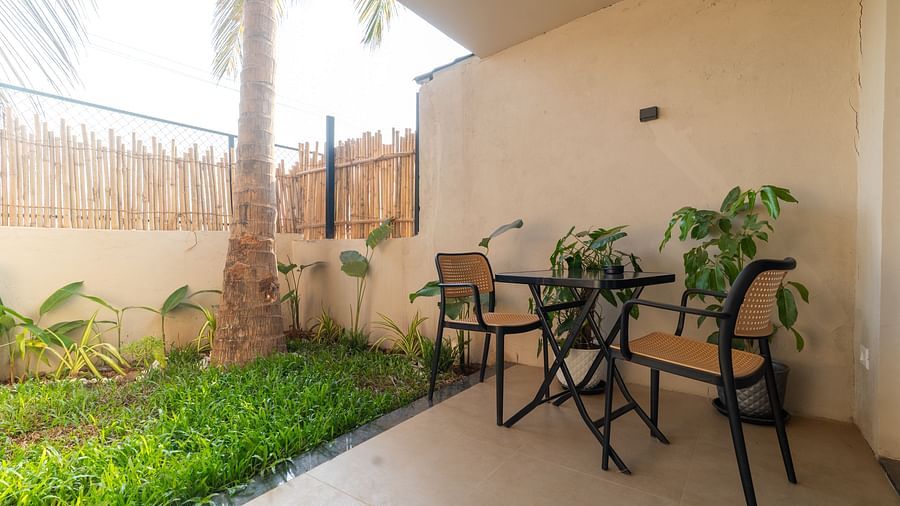 Charming private garden patio with table and chairs surrounded by greenery at Kssemya.