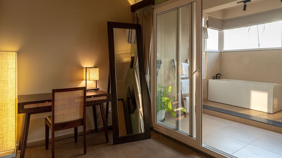 Well-lit room with work desk, mirror, and a view leading to the outdoor bathtub at Kssemya.