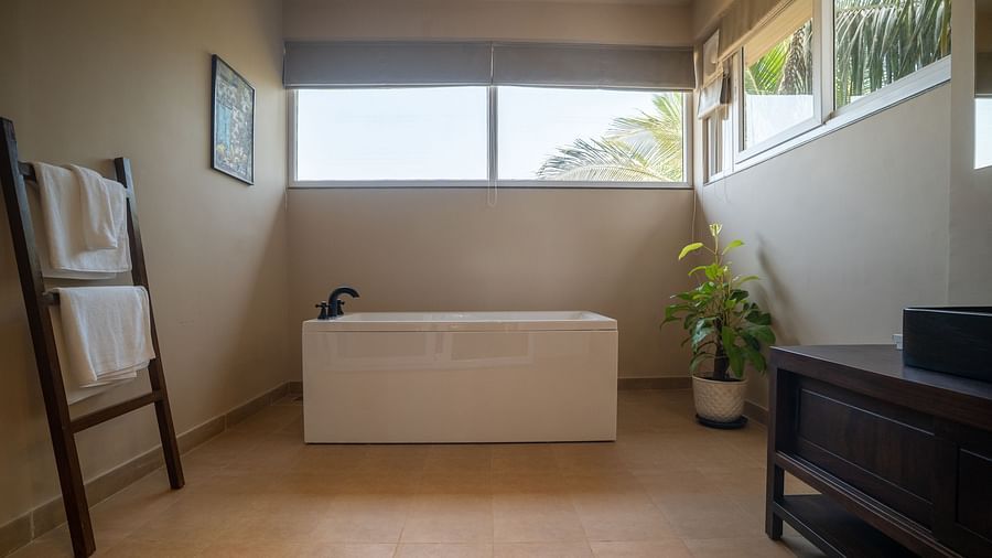 A bathroom featuring a standalone bathtub and towel ladder with natural lighting at Kssemya.