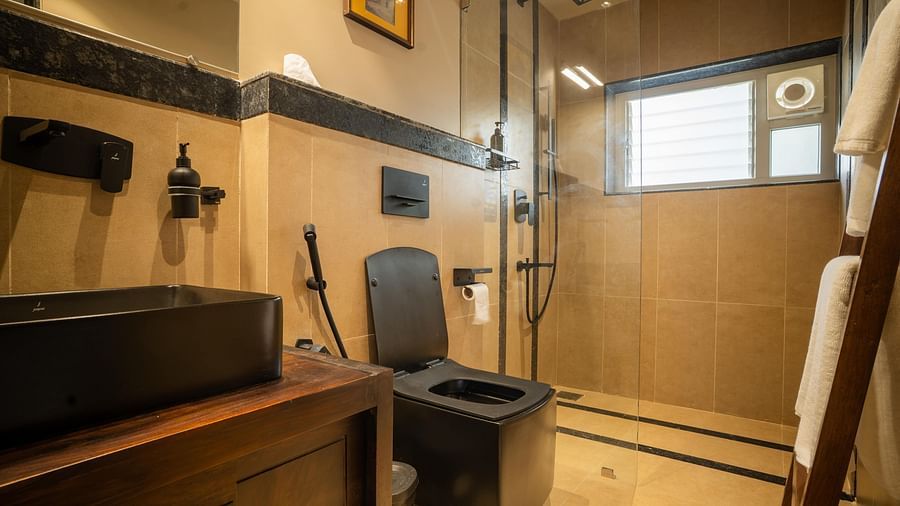 Bathroom with stylish black fixtures and warm wooden cabinetry at Kssemya.