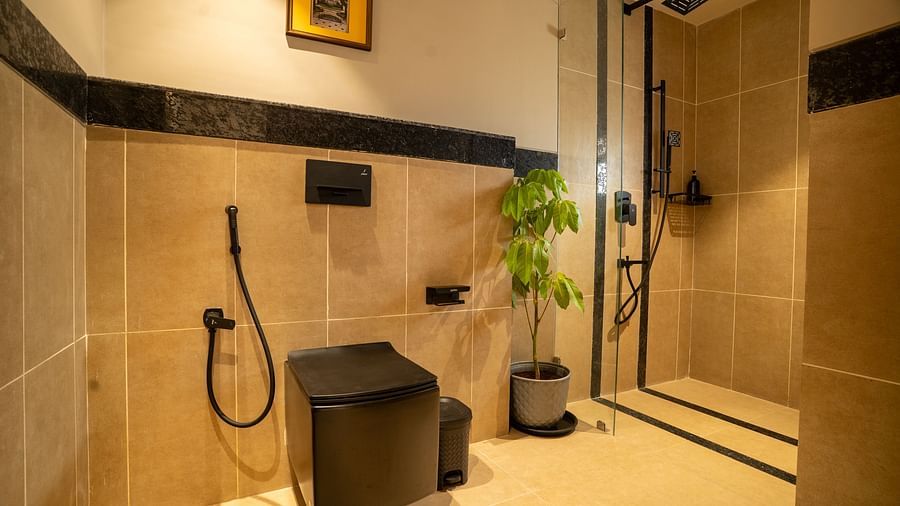 Bathroom with glass shower enclosure and elegant black fixtures at Kssemya.