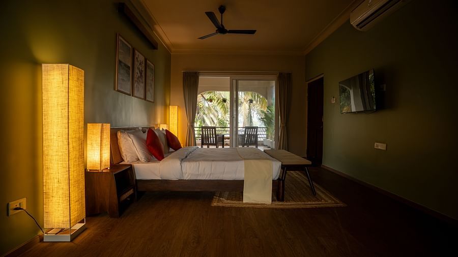 Warmly lit bedroom with double bed and soft furnishings, leading to balcony access at Kssemya.