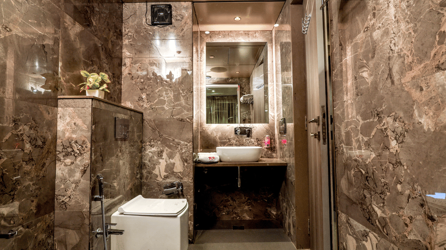 Well-appointed hotel bathroom with a sink area, mirror, toilet, and premium wall finishes at Kumar Resort by Turtle.