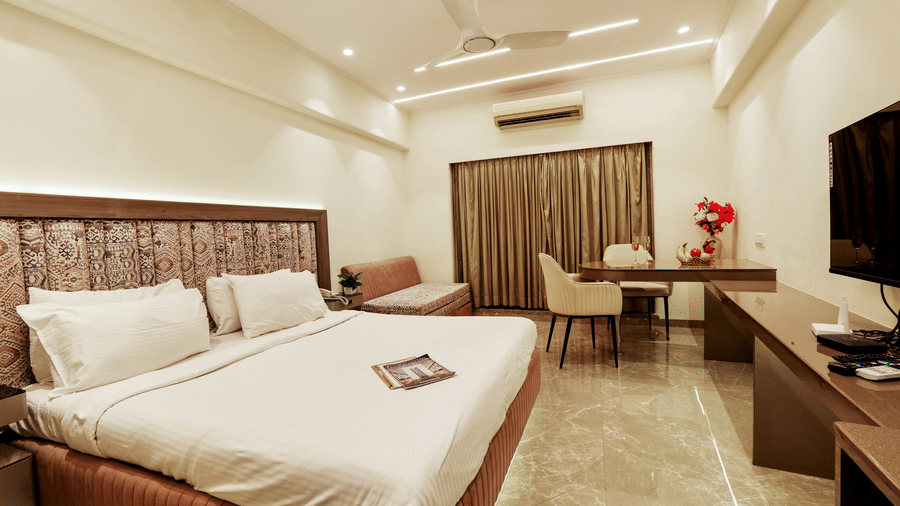 Bedroom with a bed, work desk, and warm ambience at Kumar Resort by Turtle.
