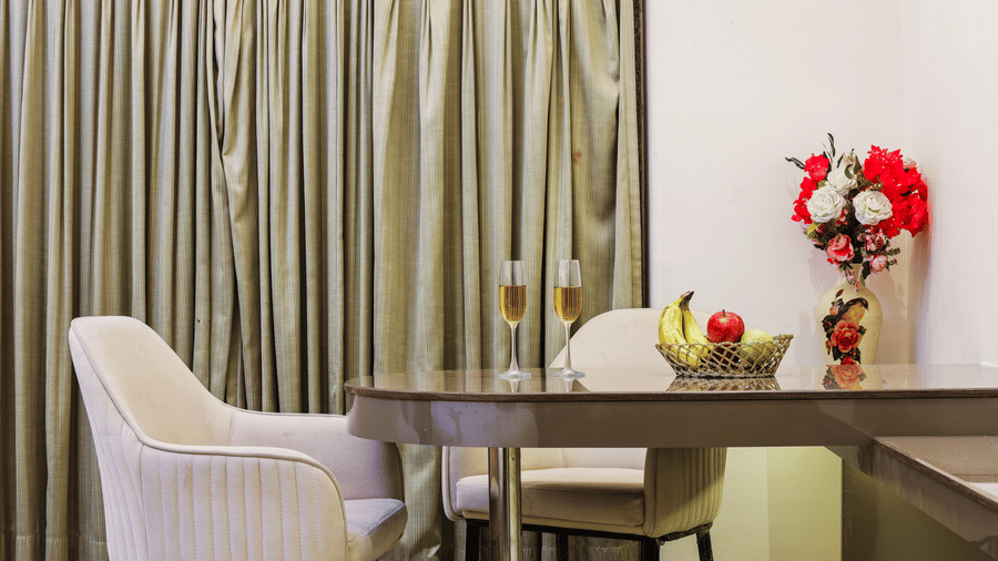 Work desk with a chair and decorative flowers beside the window at Kumar Resort by Turtle.