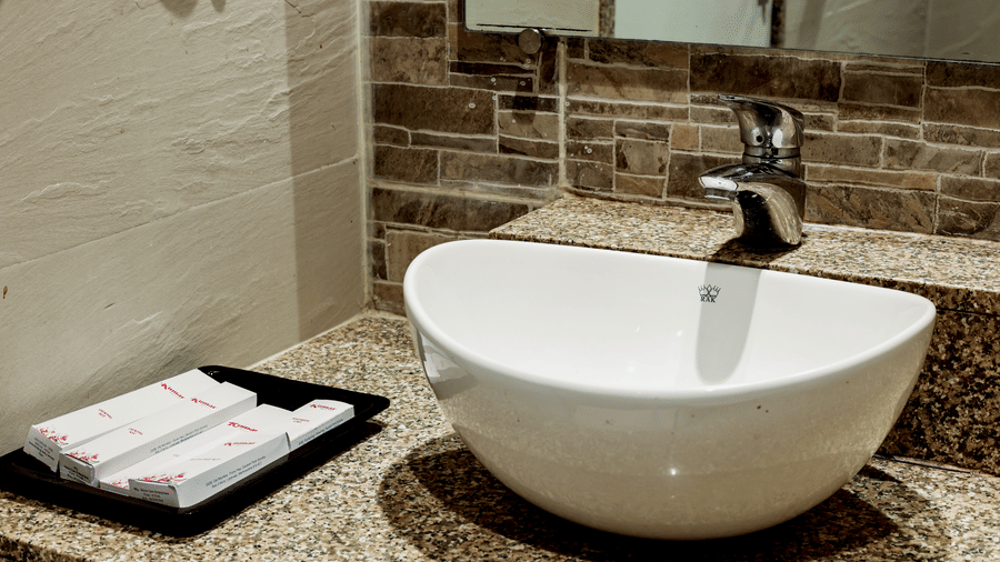 Close-up of a modern washbasin with neatly arranged toiletries at Kumar Resort by Turtle.