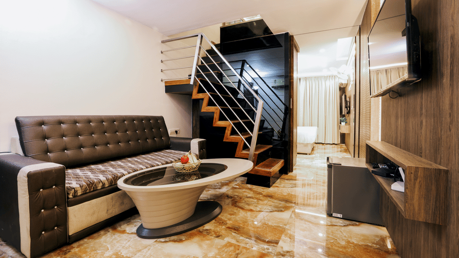 Duplex suite with sofa seating and staircase leading to the upper floor at Kumar Resort by Turtle.