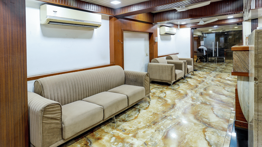 Spacious interior room, possibly a waiting area or large suite, with comfortable sofas, a polished floor, and climate control units at Kumar Resort by Turtle.