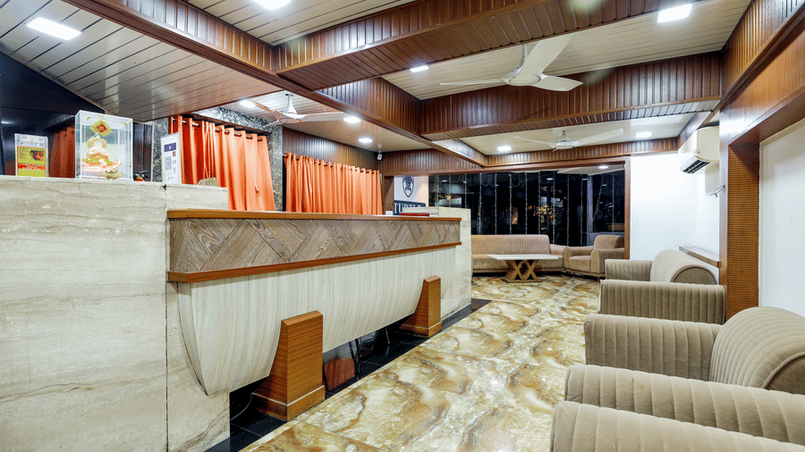 Interior view of lounge area, featuring comfortable seating arrangements, wood paneling, and decorative partitions at Kumar Resort by Turtle.